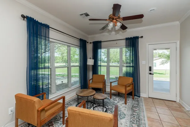 a living room with furniture and large windows