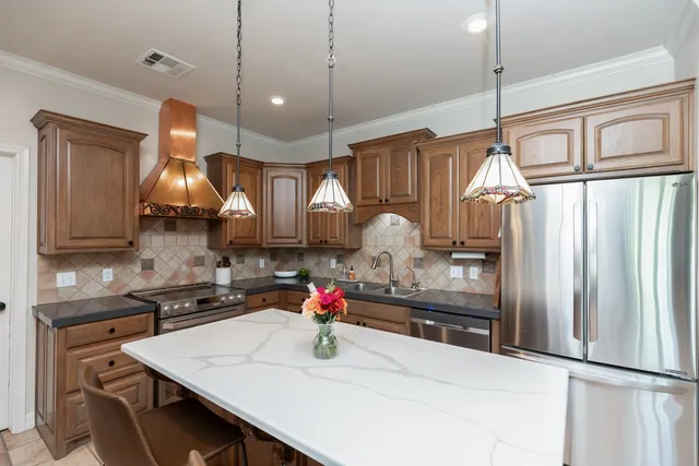 a kitchen with stainless steel appliances a sink stove and refrigerator