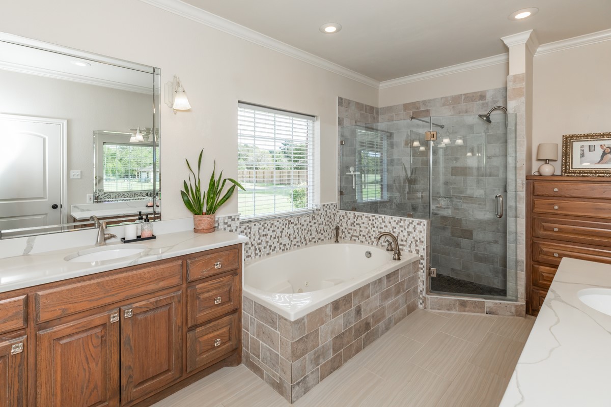 430 Bonura Road Sour Lake, TX 77659 - Photo 28 of 50 a bathroom with a bathtub a double vanity sink a vanity a window and a shower