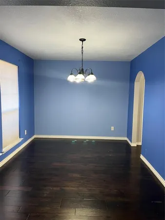 a view of wooden floor chandelier and window in a room