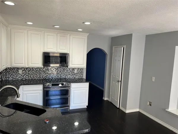 a kitchen with stainless steel appliances granite countertop a refrigerator and a sink