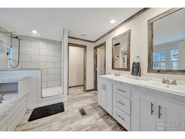 a bedroom with a bed a mirror on dresser and a flat screen tv