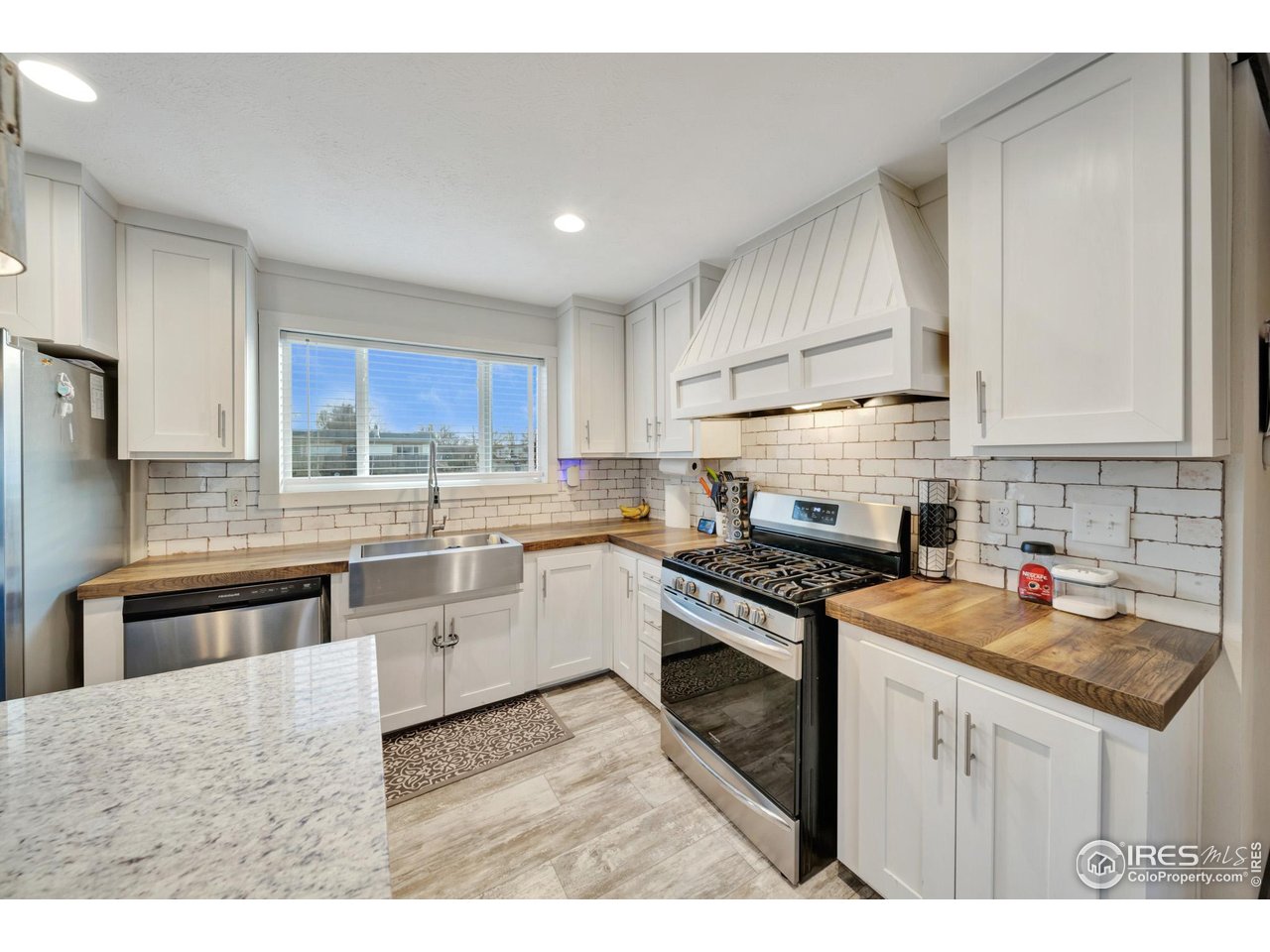 116 Ash Street Log Lane Village, CO 80705 - Photo 15 of 21 a kitchen with stainless steel appliances granite countertop a sink stove and refrigerator