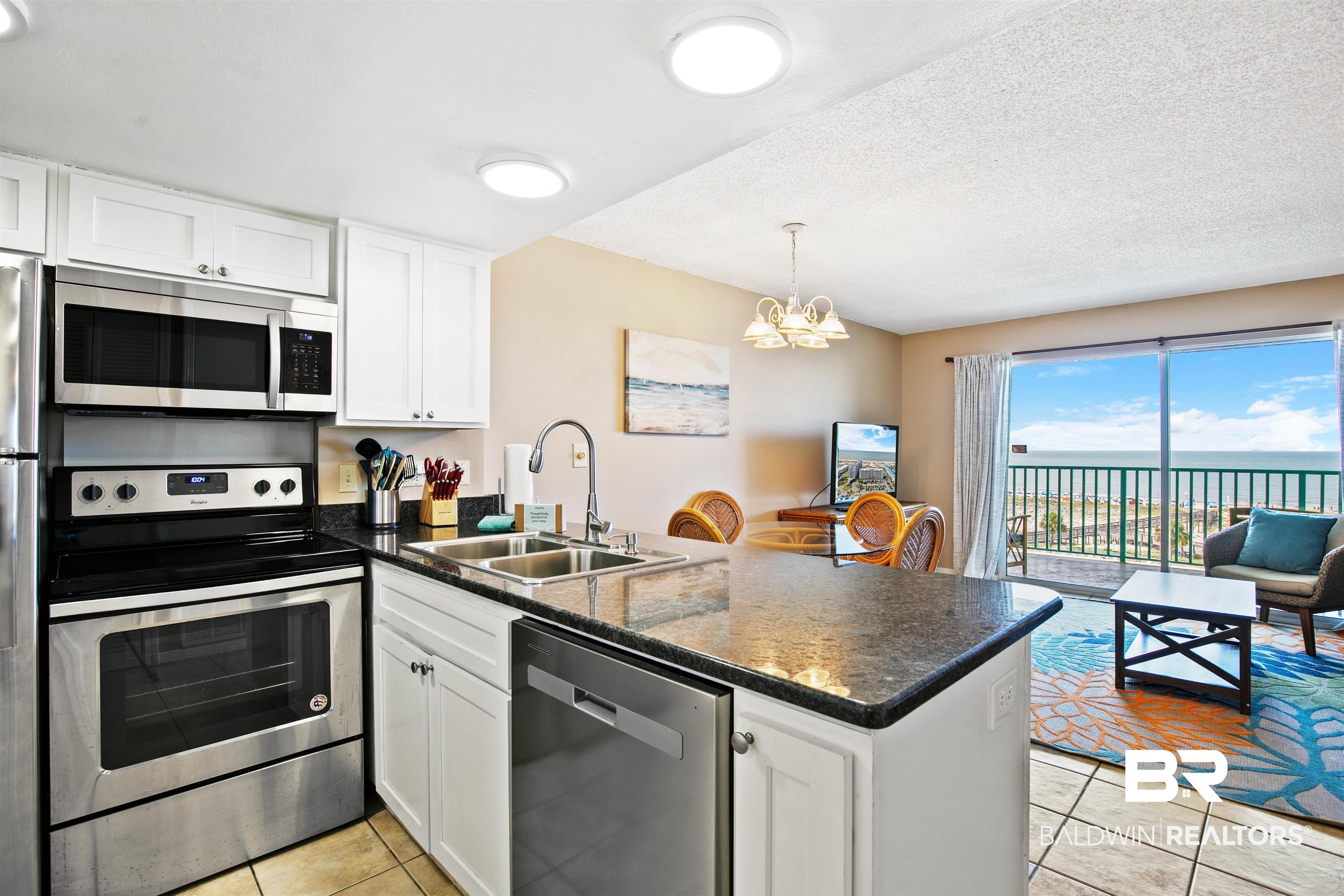 645 Plantation Road, Unit 6606 Gulf Shores, AL 36542 - Photo 11 of 60 Kitchen with white cabinetry, stainless steel appliances, and dark countertops