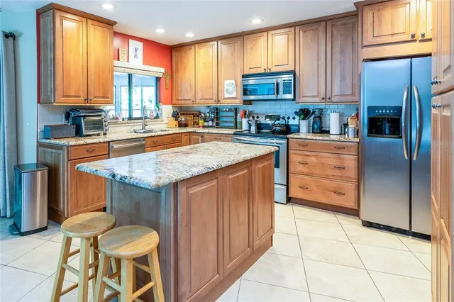 a kitchen with stainless steel appliances granite countertop a stove top oven a sink dishwasher and cabinets with wooden floor