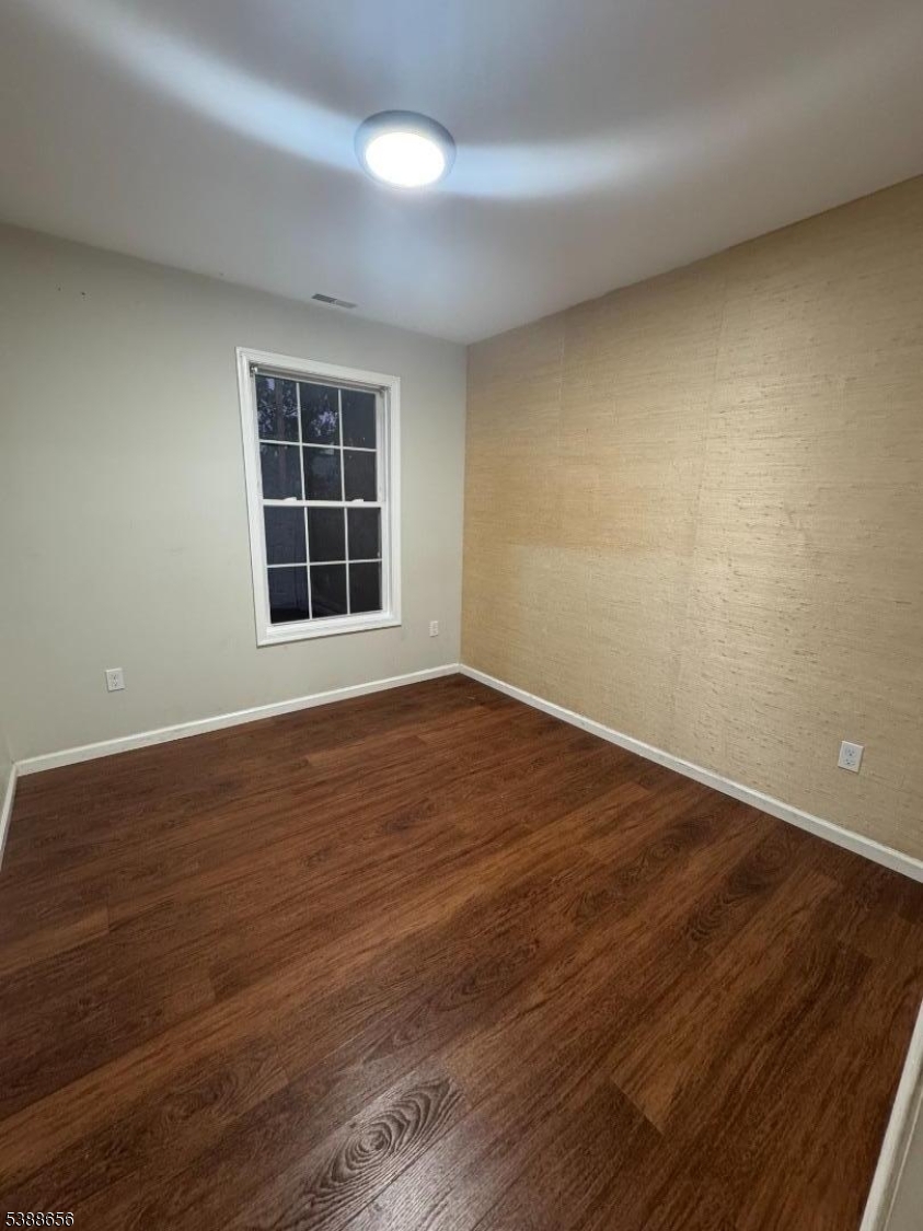 406 South 7th Street, Unit 2 Newark, NJ 07103 - Photo 9 of 13 an empty room with wooden floor and windows