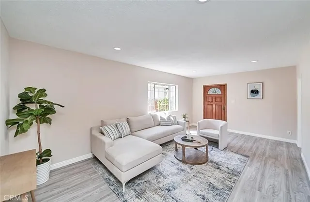 a living room with furniture potted plant and wooden floor