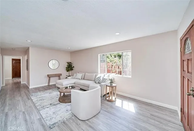a living room with furniture a window and wooden floor