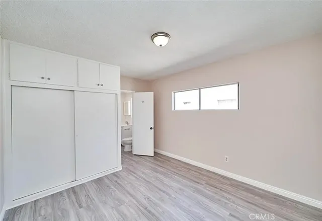 a view of an empty room with closet and a window