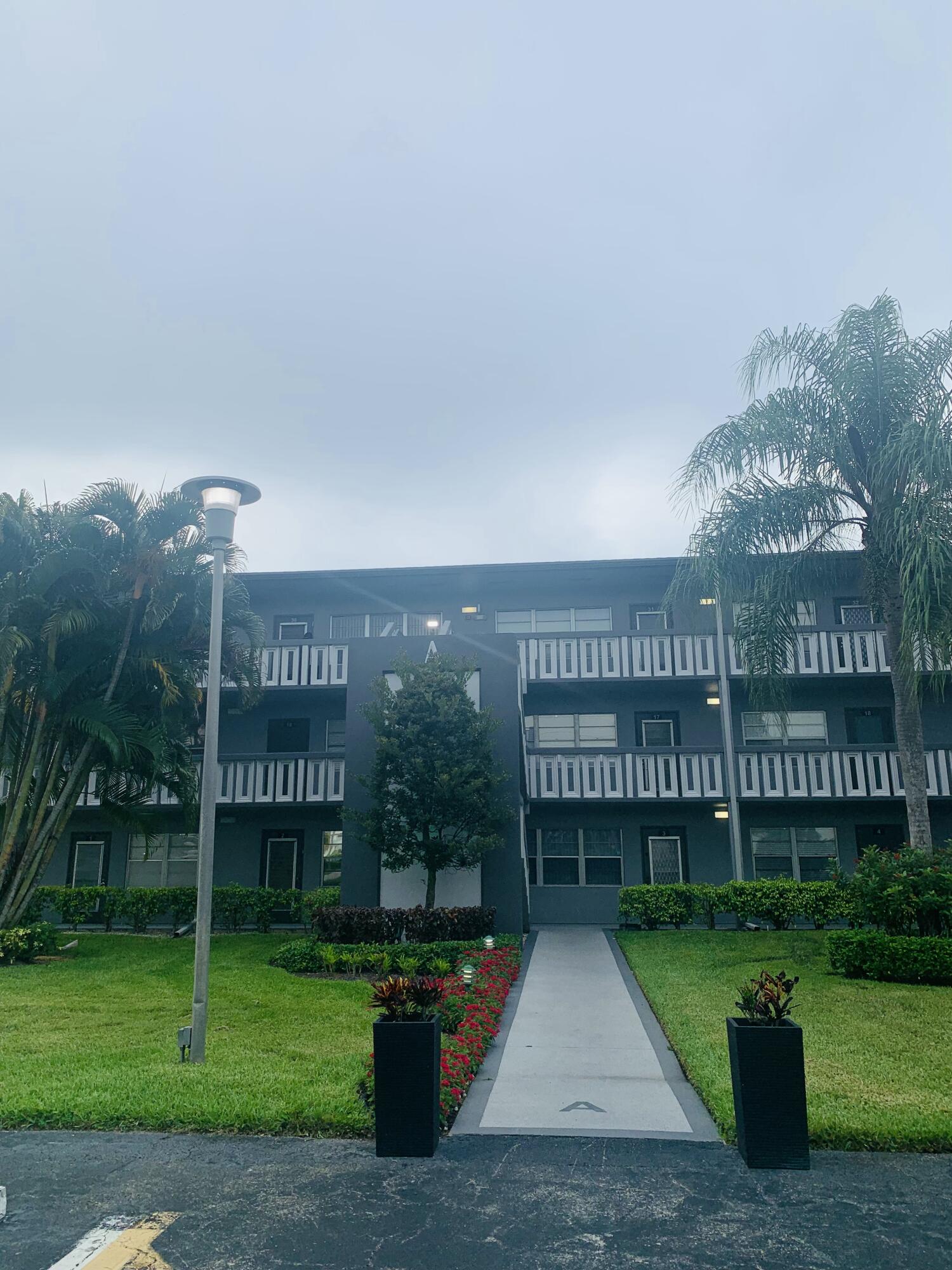 7 Suffolk A Boca Raton, FL 33434 - Photo 4 of 19 a front view of a building with garden