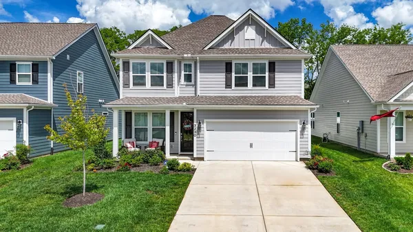 a front view of a house with a garden and plants