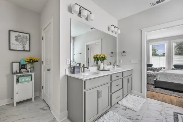 a en suite bathroom with a granite countertop sink and a mirror
