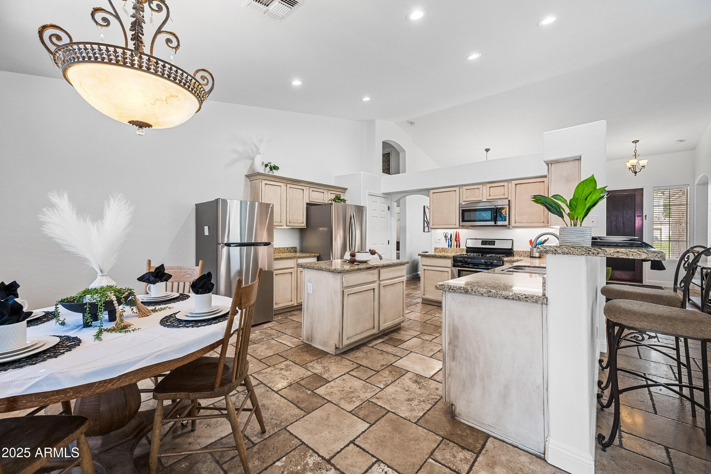 1541 West Chilton Avenue Gilbert, AZ 85233 - Photo 14 of 71 a kitchen with stainless steel appliances kitchen island granite countertop a refrigerator a stove a sink a dining table and chairs with wooden floor