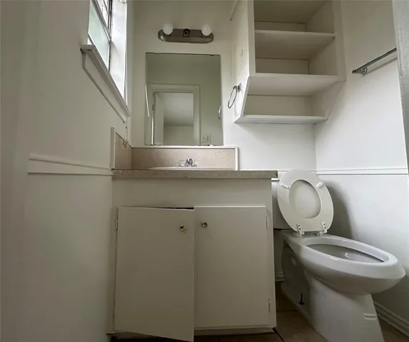 a bathroom with a sink mirror vanity and toilet