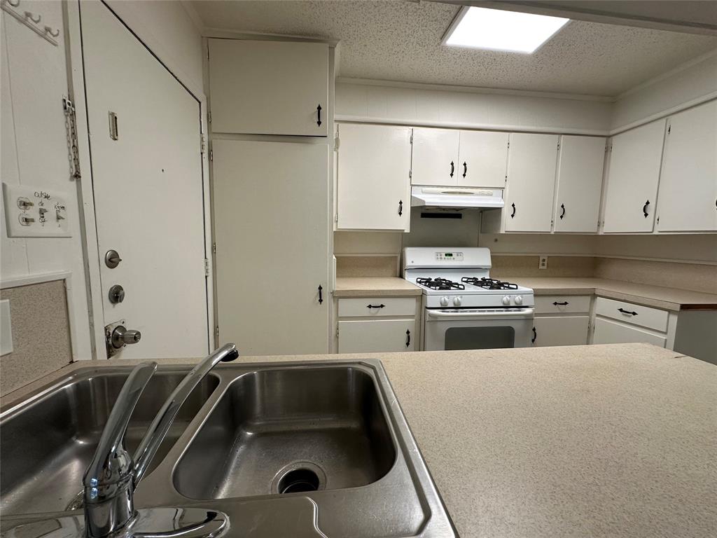 2109 Quail Run, Unit A McKinney, TX 75071 - Photo 6 of 16 a kitchen with stainless steel appliances a stove a sink and white cabinets
