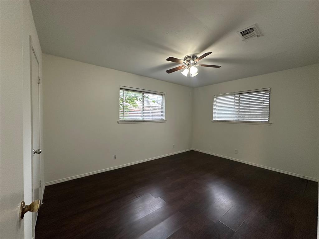 2109 Quail Run, Unit A McKinney, TX 75071 - Photo 8 of 16 a view of an empty room with a window and wooden floor