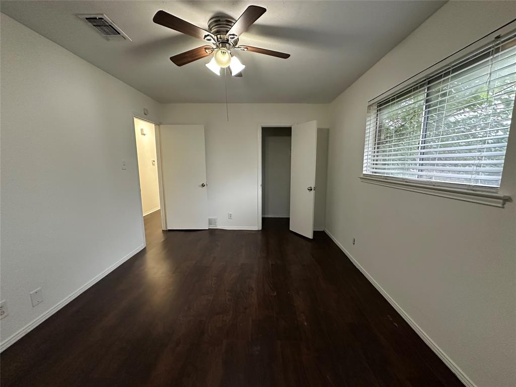 2109 Quail Run, Unit A McKinney, TX 75071 - Photo 9 of 16 a view of an empty room with wooden floor and a window