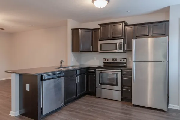 a kitchen with granite countertop stainless steel appliances and wooden cabinets