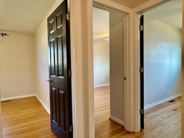 a view of a hallway with wooden floor and staircase