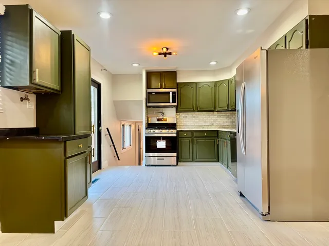 a kitchen with stainless steel appliances kitchen island a refrigerator and a stove