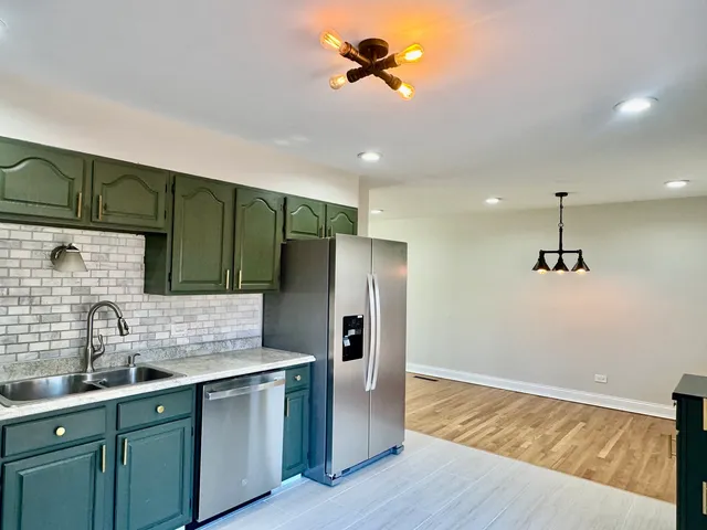 a kitchen with kitchen island a sink appliances and cabinets