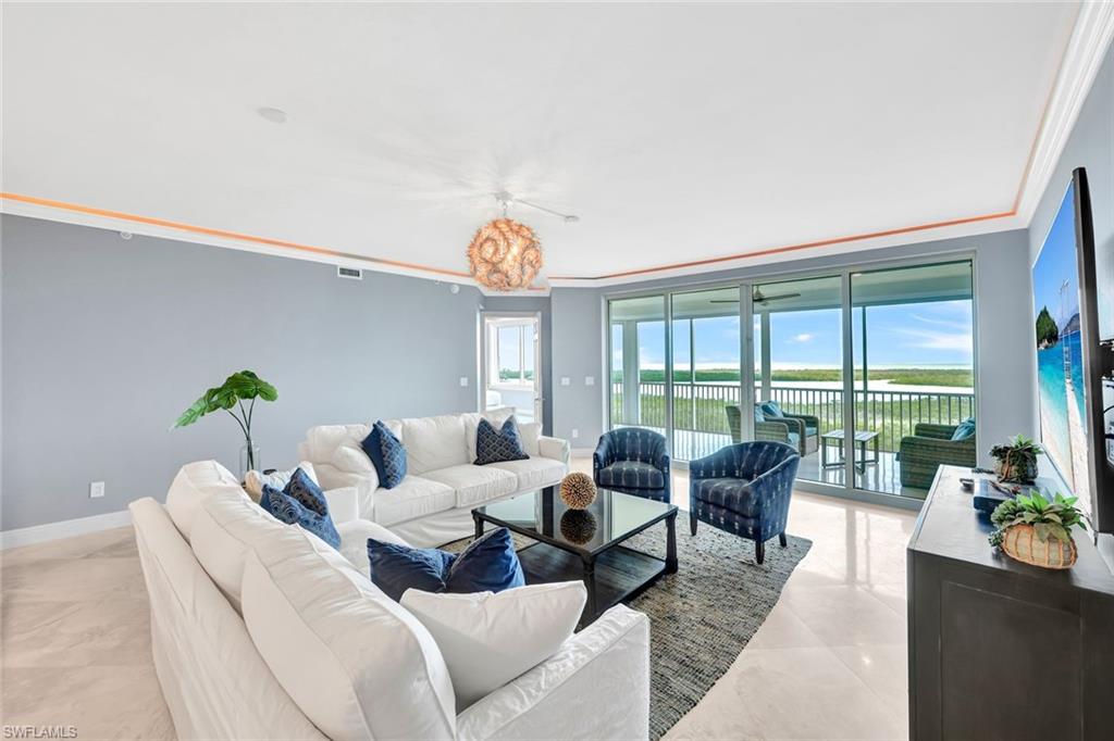 a living room with furniture and floor to ceiling windows