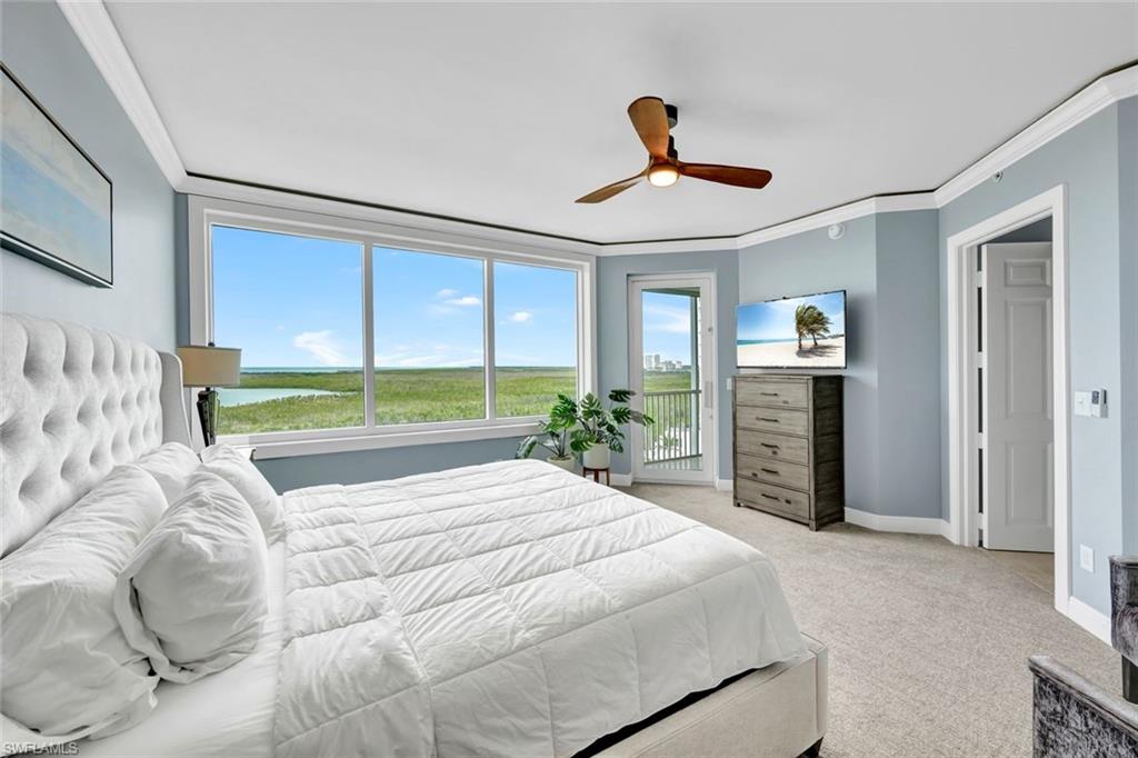 275 Indies Way, Unit 902 Naples, FL 34110 - Photo 13 of 39 a bedroom with a bed and a large window