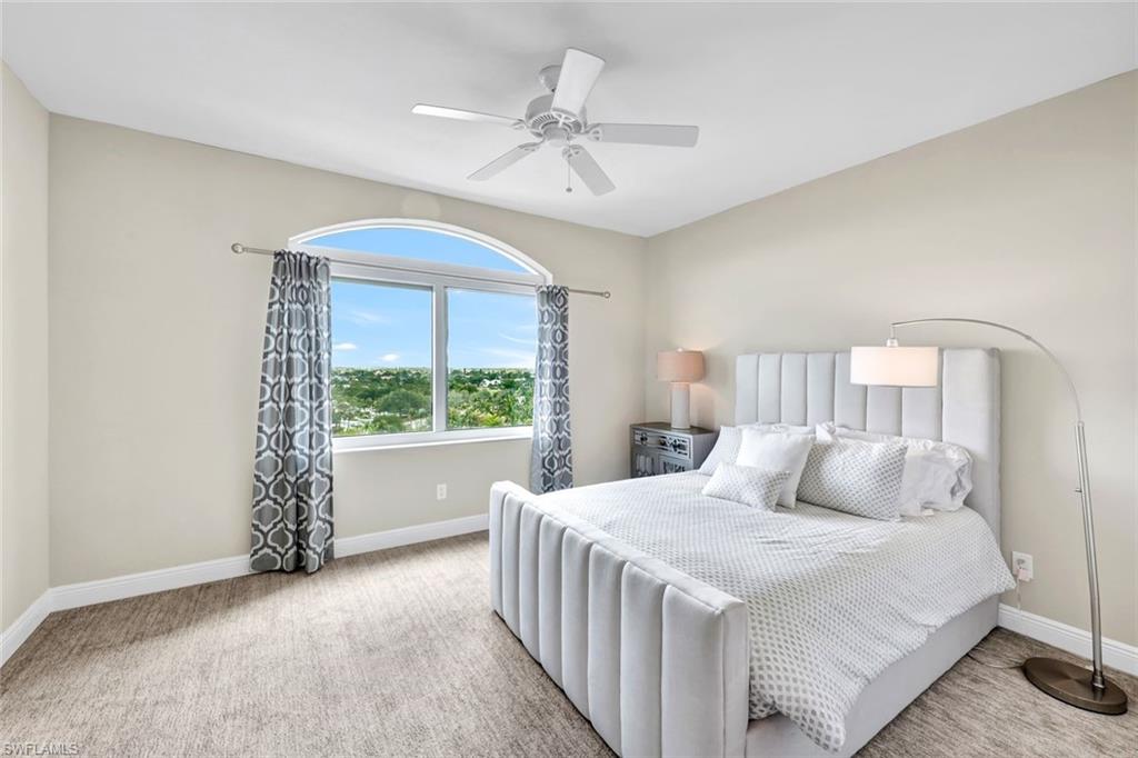 275 Indies Way, Unit 902 Naples, FL 34110 - Photo 16 of 39 a bedroom with a bed and a large window