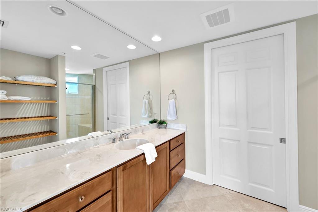 275 Indies Way, Unit 902 Naples, FL 34110 - Photo 19 of 39 a bathroom with a sink double vanity and a mirror