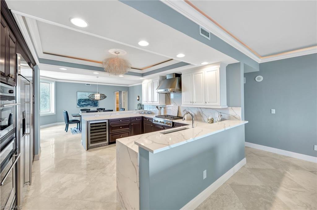 275 Indies Way, Unit 902 Naples, FL 34110 - Photo 7 of 39 a large white kitchen with a large counter top appliances and cabinets