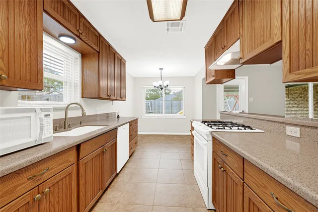a kitchen with stainless steel appliances granite countertop a sink stove and cabinets