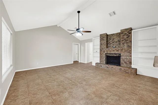 a view of empty room with fireplace and windows