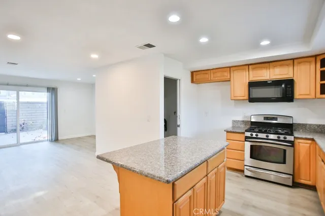 a kitchen with stainless steel appliances granite countertop a stove a sink and a microwave