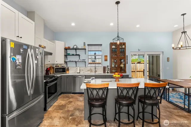 a kitchen with refrigerator cabinets dining table and chairs