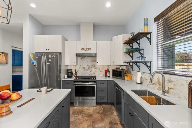 a kitchen with stainless steel appliances kitchen island granite countertop a sink stove and refrigerator