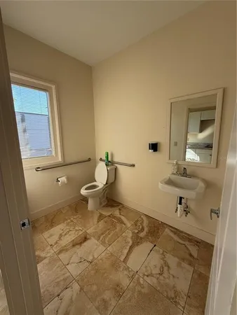 a bathroom with a sink a toilet and mirror