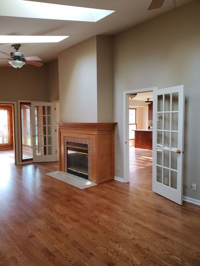 950 Ripple Brook Lane Elgin, IL 60120 - Photo 14 of 38 an empty room with wooden floor fireplace and windows