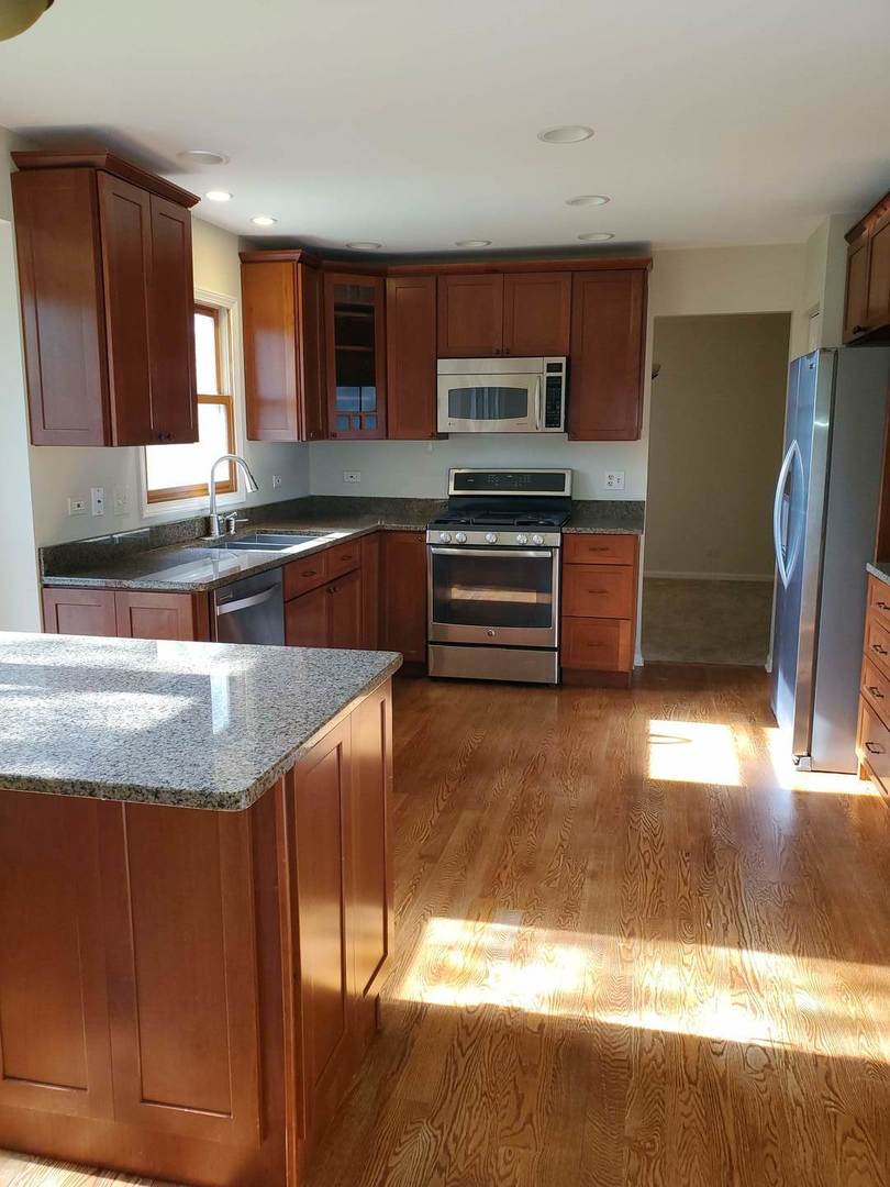 950 Ripple Brook Lane Elgin, IL 60120 - Photo 10 of 38 a kitchen with stainless steel appliances granite countertop a sink stove and refrigerator