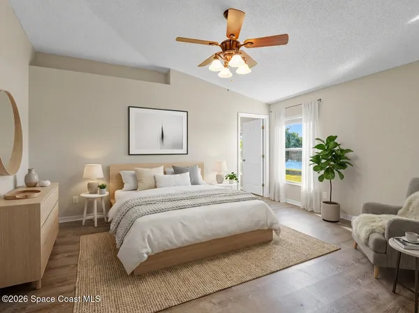 a spacious bedroom with a bed a couch and potted plant