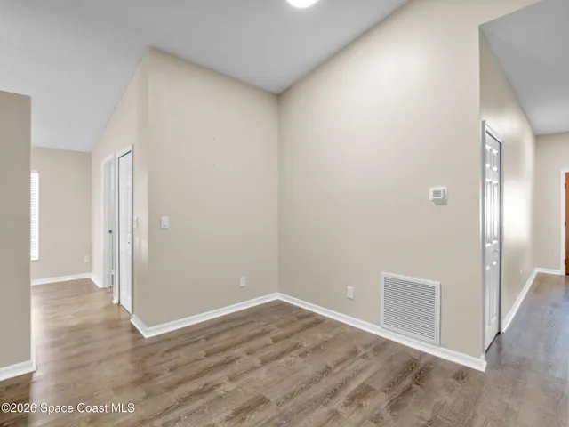 a view of an empty room with wooden floor