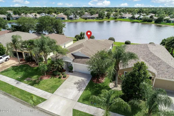 an aerial view of a house with a yard and lake view