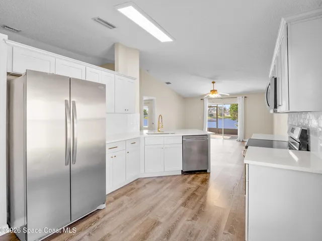 a kitchen with a refrigerator sink and cabinets