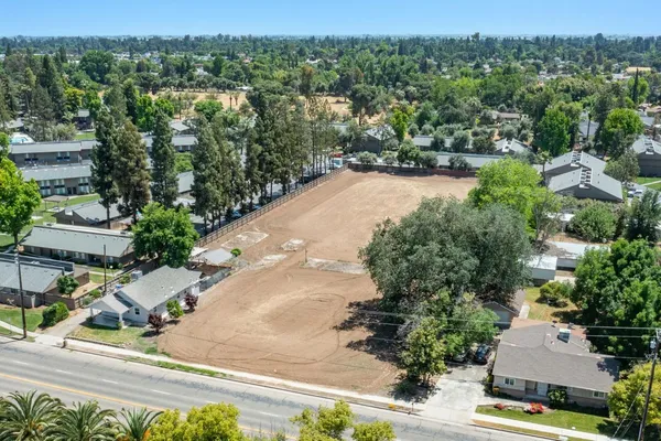 an aerial view of residential houses with outdoor space and trees