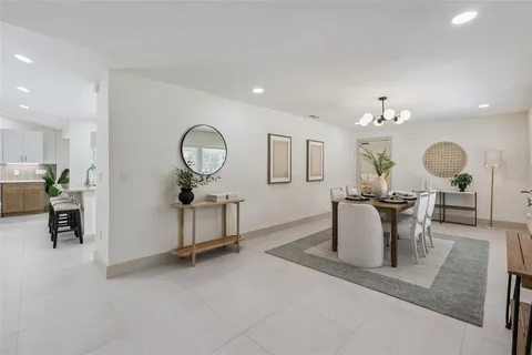 a living room with furniture a potted plant and a chandelier
