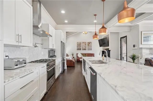 a kitchen with a stove a sink a refrigerator and a fireplace