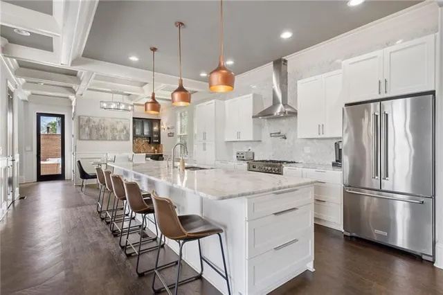 a kitchen with stainless steel appliances granite countertop a lot of counter space and wooden floors