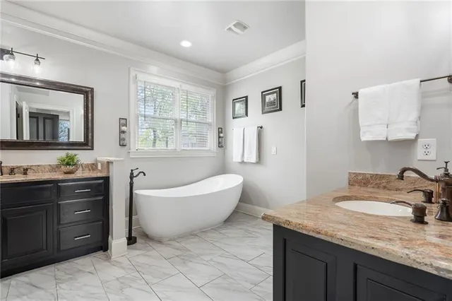 a bathroom with a bathtub a mirror a window and a shower