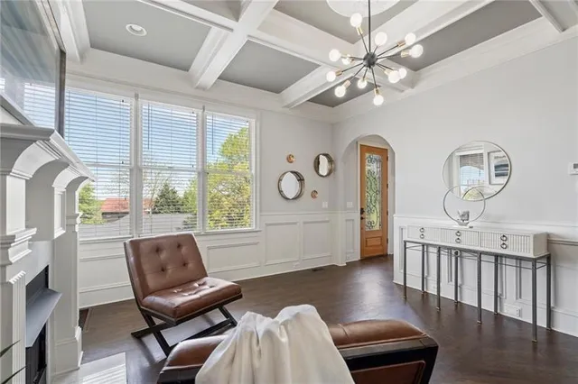 a living room with furniture chandelier and a large window