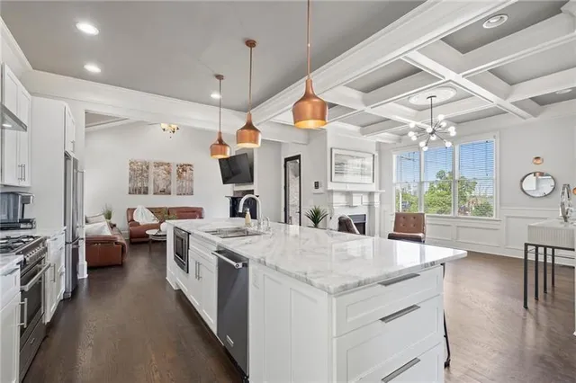 a large kitchen with kitchen island a stove a sink a dining table and chairs