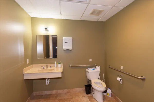a bathroom with a sink mirror vanity and toilet
